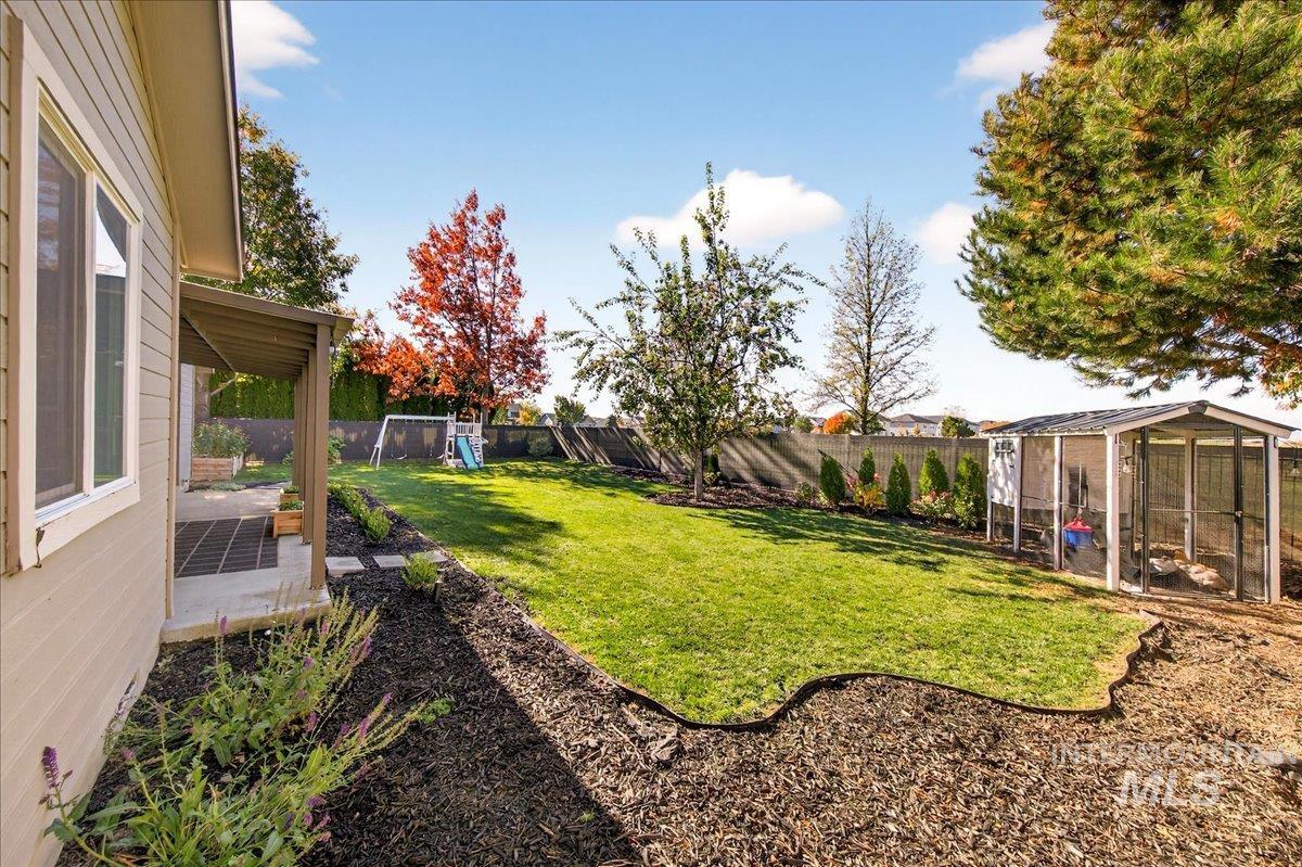 Fenced backyard featuring exterior structure, an outdoor structure, and a patio area