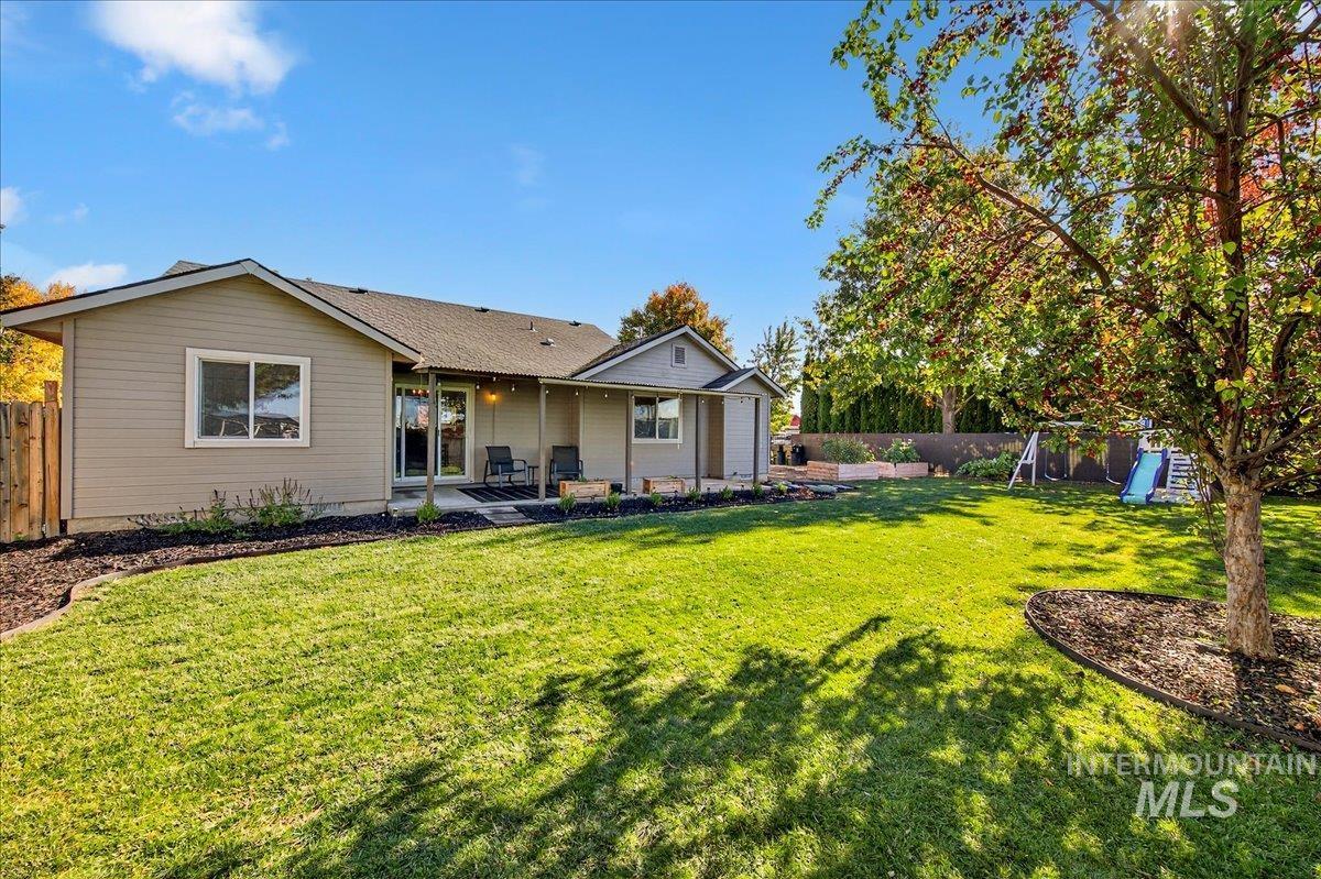 Rear view of house with a patio area, a fenced backyard, and a playground
