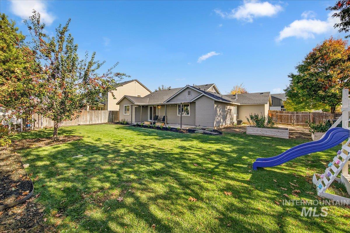 Rear view of property with a fenced backyard, a patio, and a playground