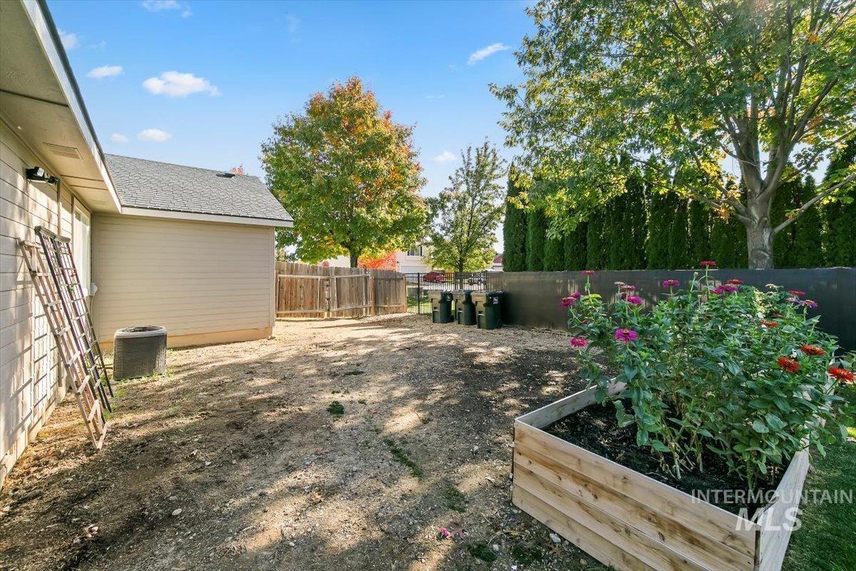 Fenced backyard featuring a garden