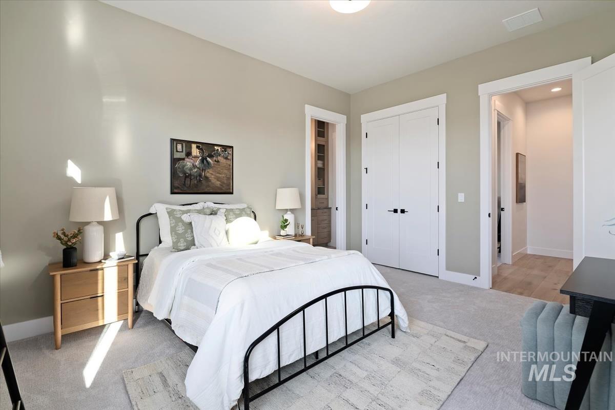 Bedroom featuring light colored carpet and a closet