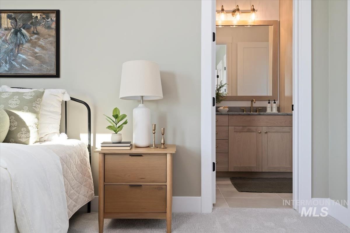 Bedroom featuring light tile patterned flooring and ensuite bath