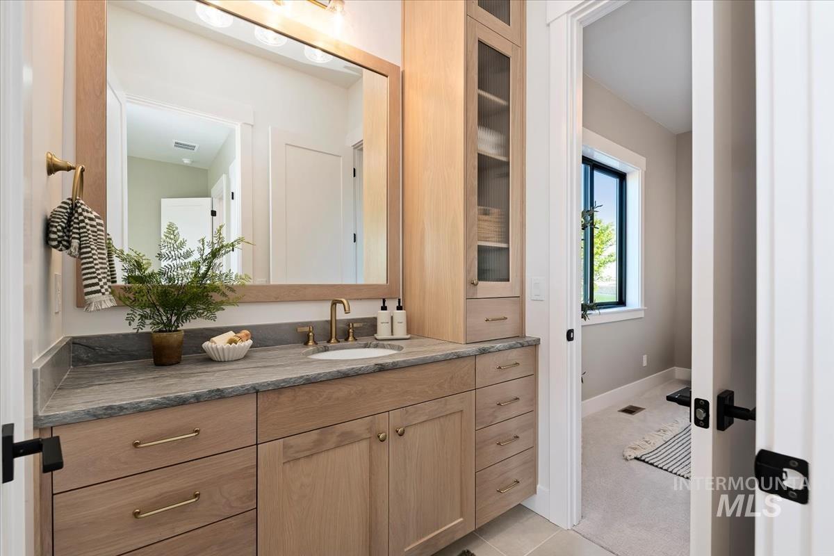 Bathroom with vanity, light carpet, and light tile patterned floors