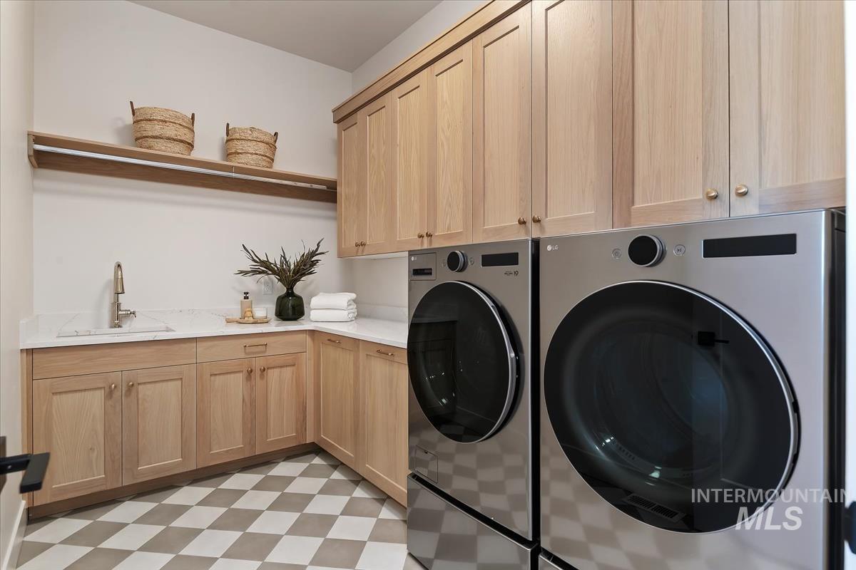 Laundry room featuring light flooring, washing machine and dryer, and cabinet space