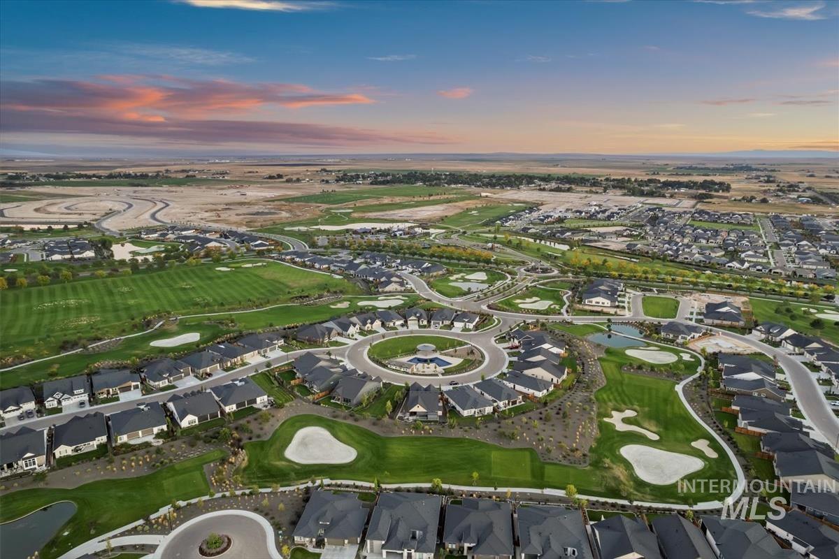 Aerial view of property's location with a golf course and nearby suburban area