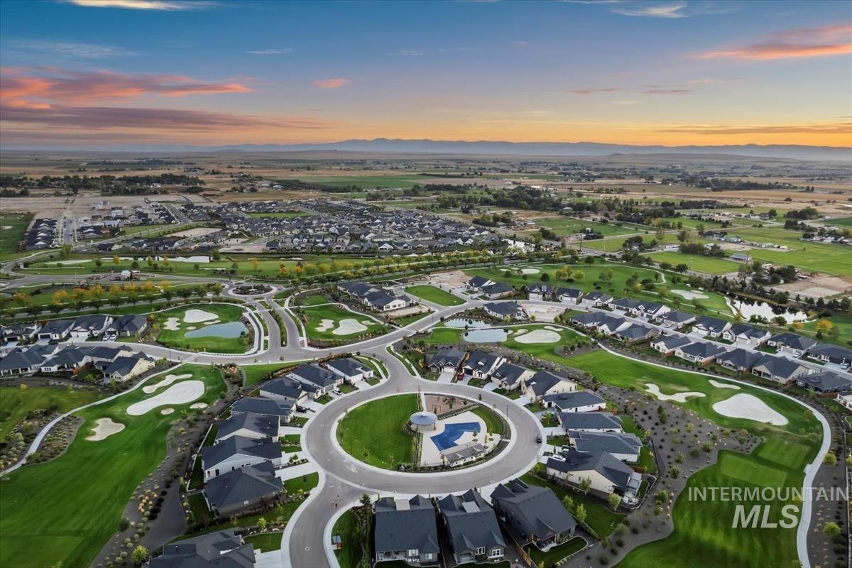 Aerial view at dusk of a water and mountain view, view of golf course, and a residential view