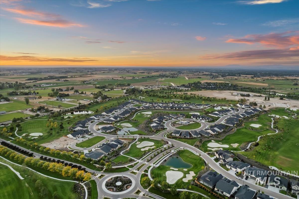 Aerial view at dusk of a water view, golf course view, and a residential view