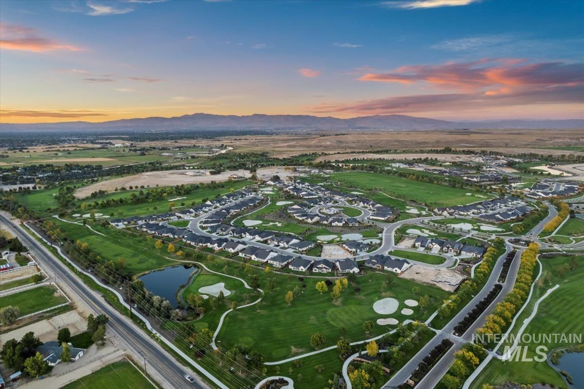 Aerial view at dusk of a water and mountain view, view of golf course, and a residential view