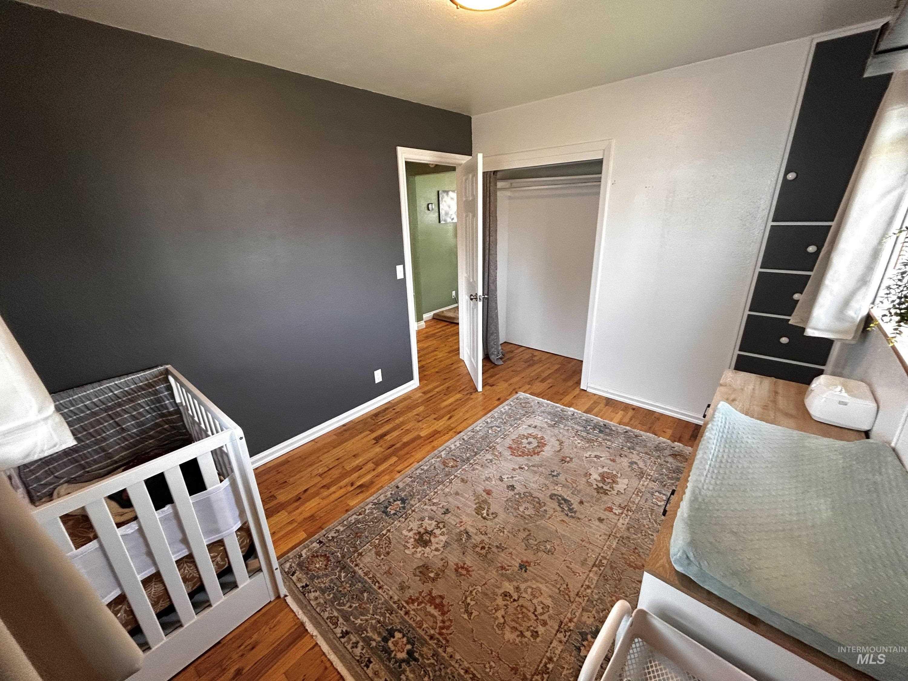 Bedroom with wood finished floors and a closet