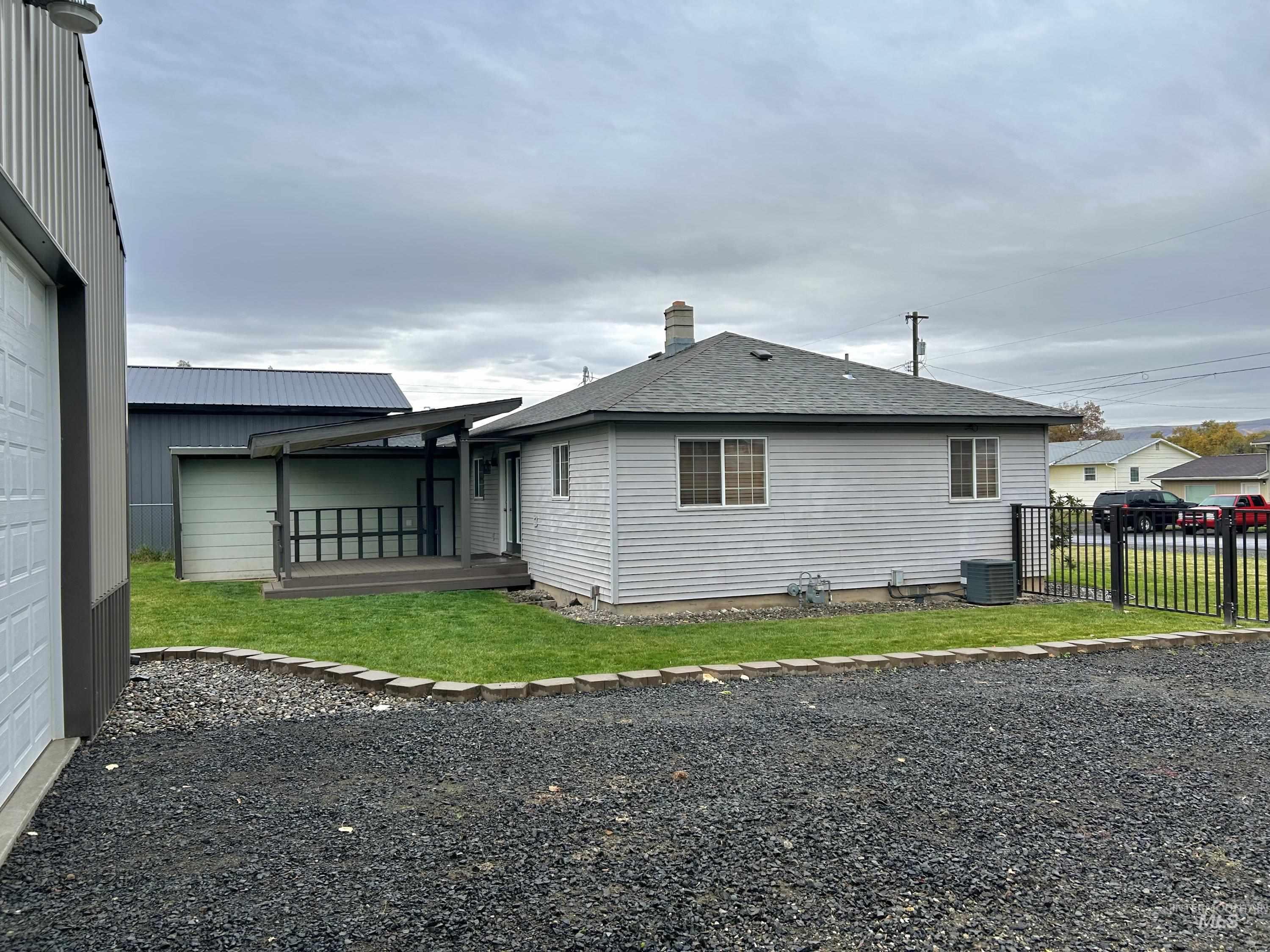 View of property exterior featuring a wooden deck, a shingled roof, and a chimney