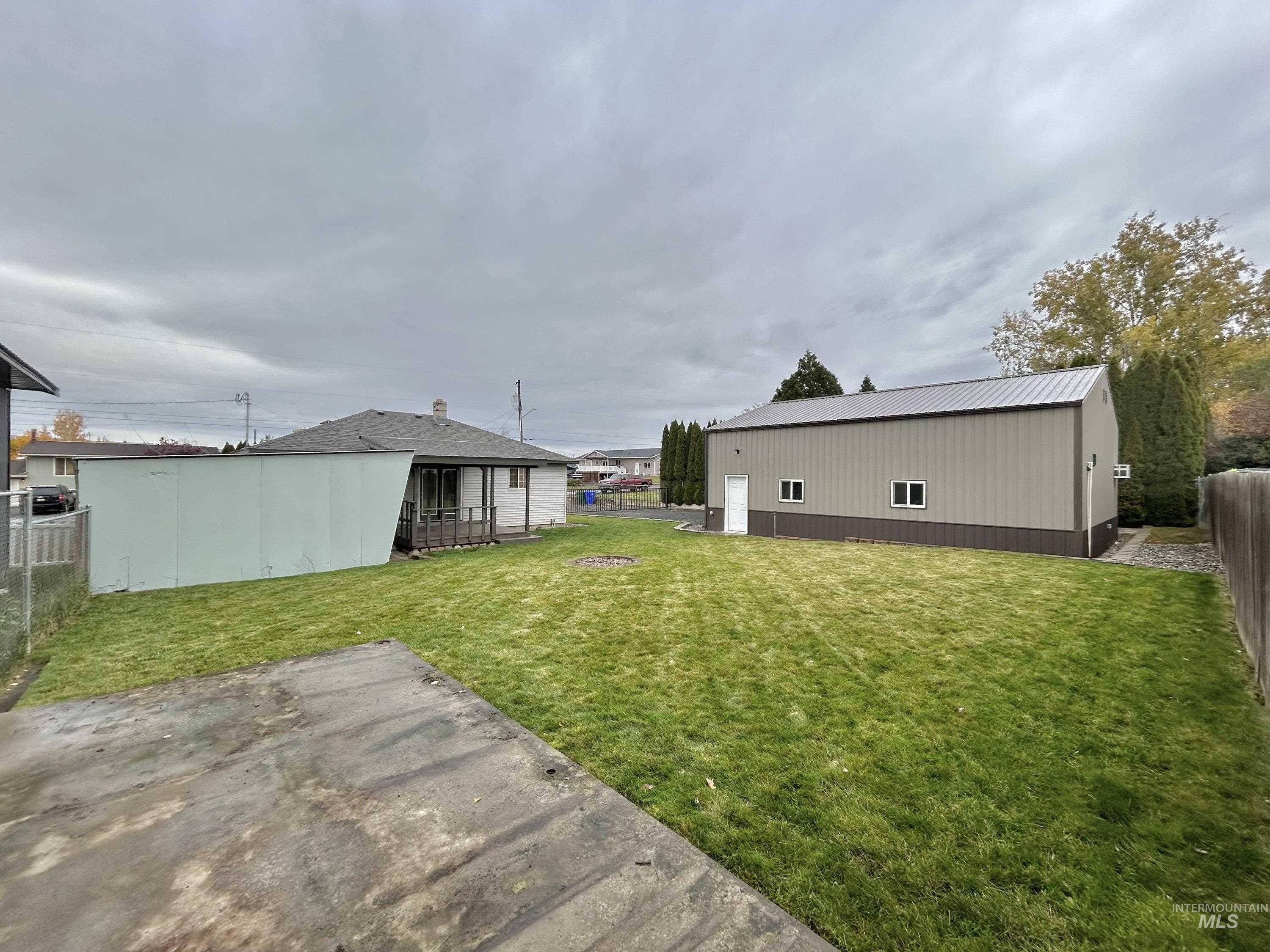 Fenced backyard featuring an outbuilding