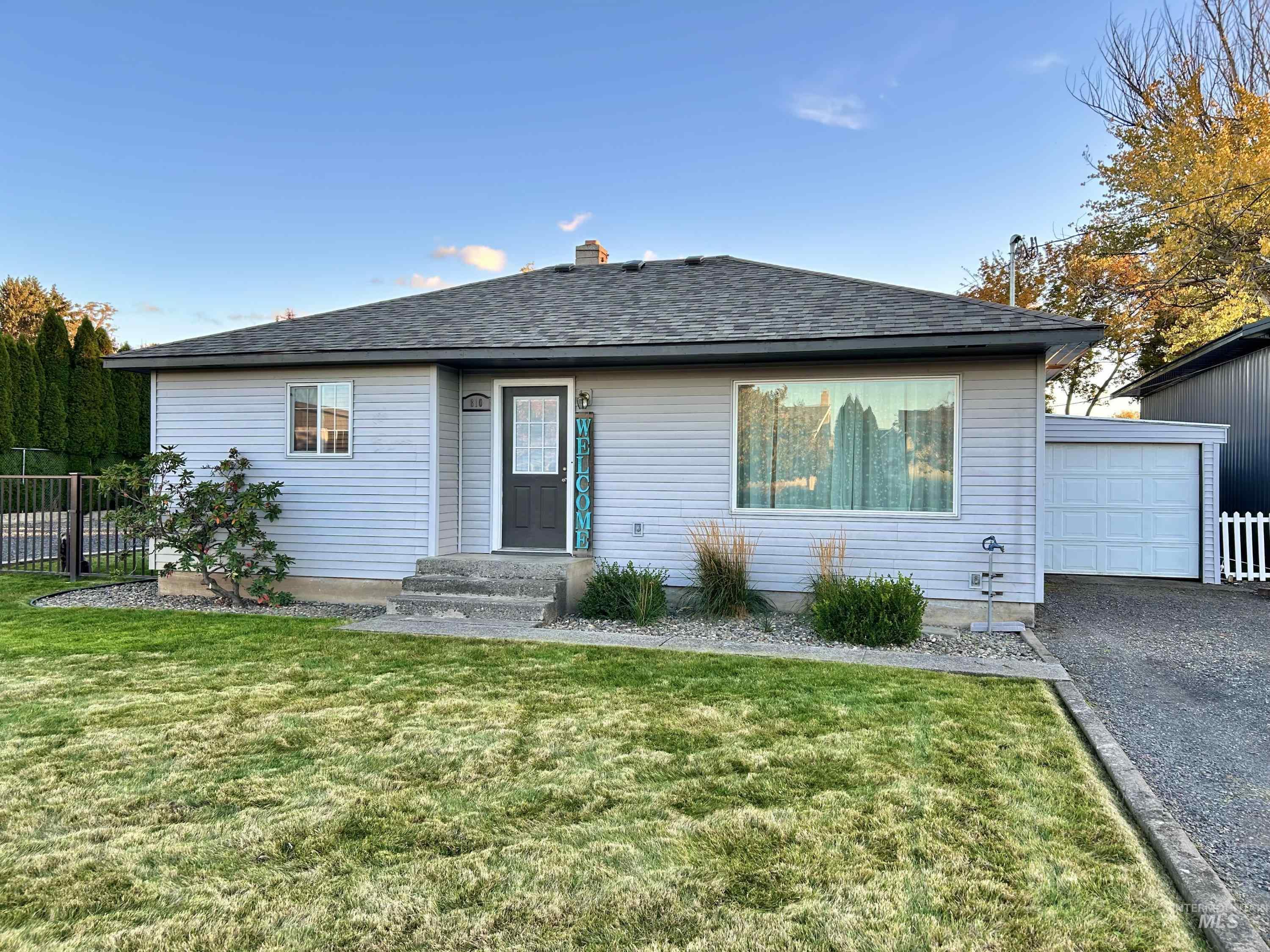 Ranch-style home featuring a garage, a shingled roof, and a chimney