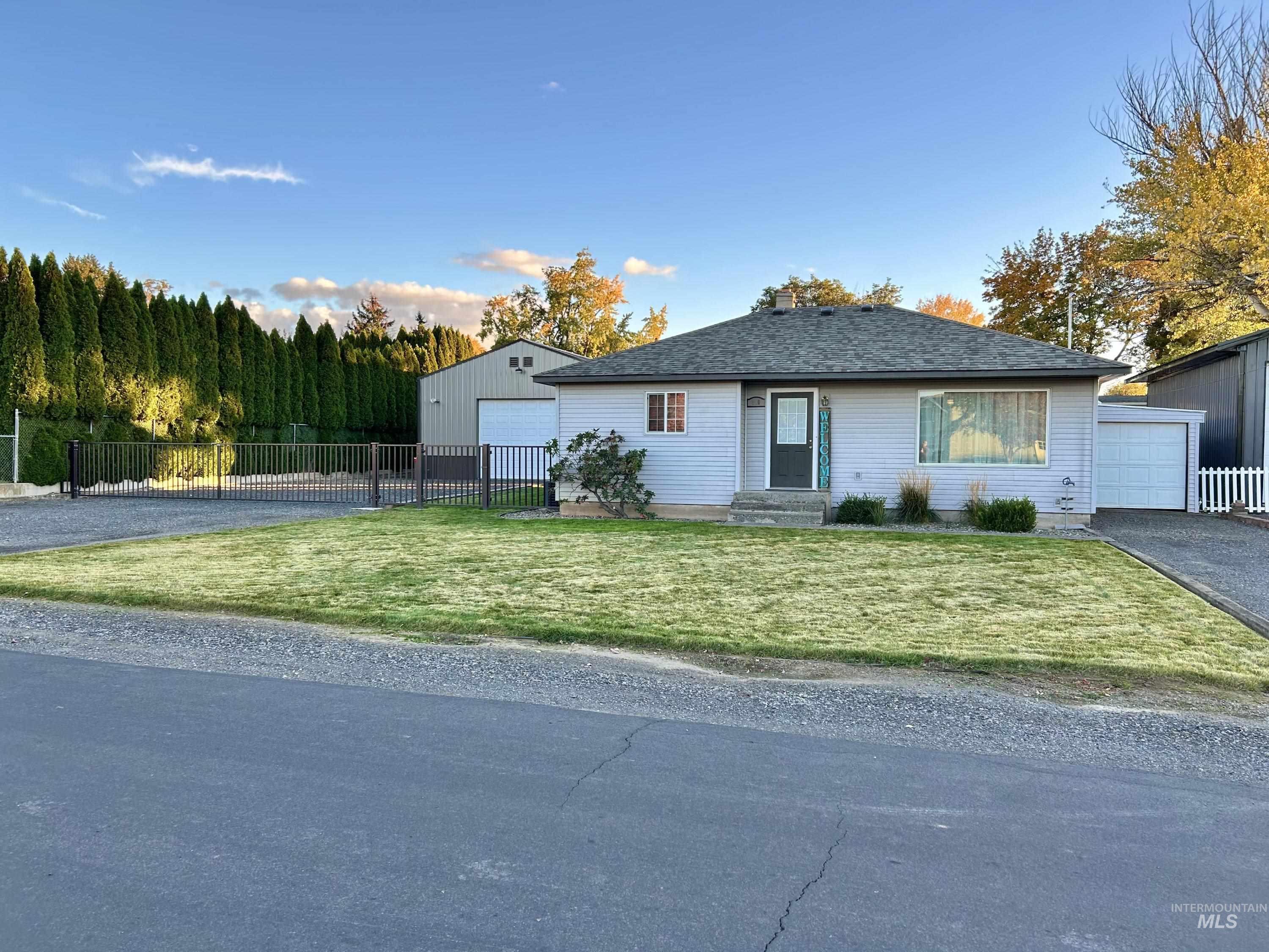 Ranch-style house with an outbuilding, asphalt driveway, and a garage
