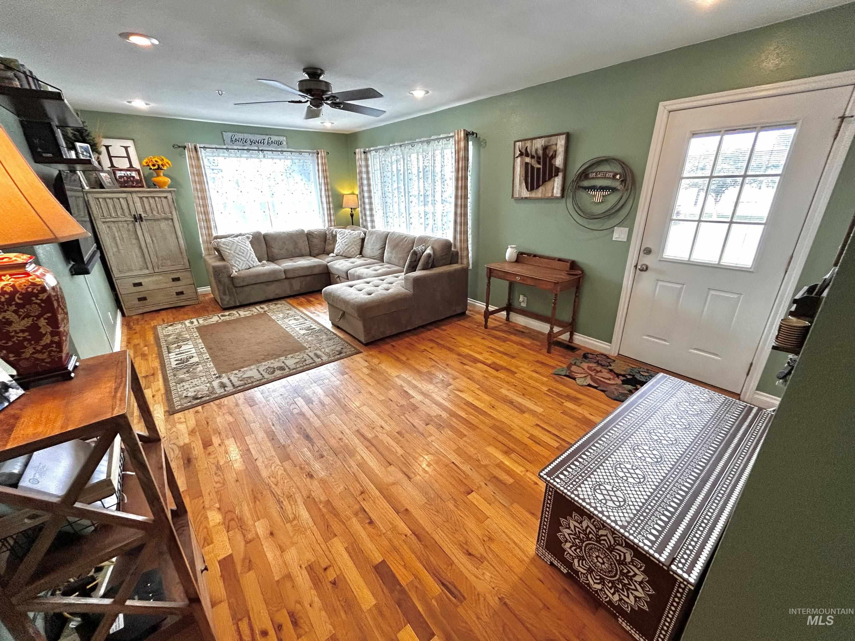 Living room with plenty of natural light, light wood-style floors, recessed lighting, and ceiling fan