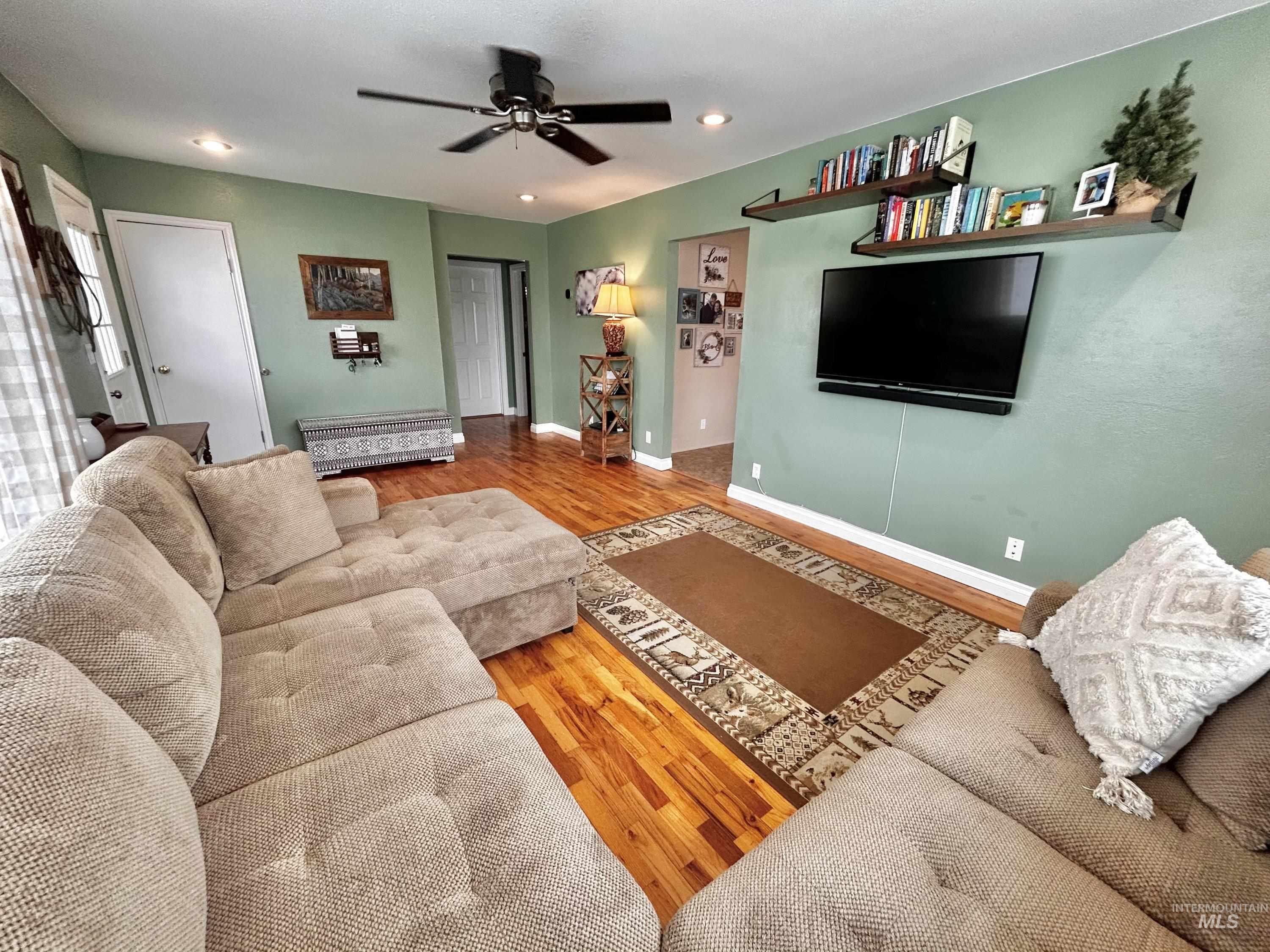 Living room featuring wood finished floors, a ceiling fan, and recessed lighting