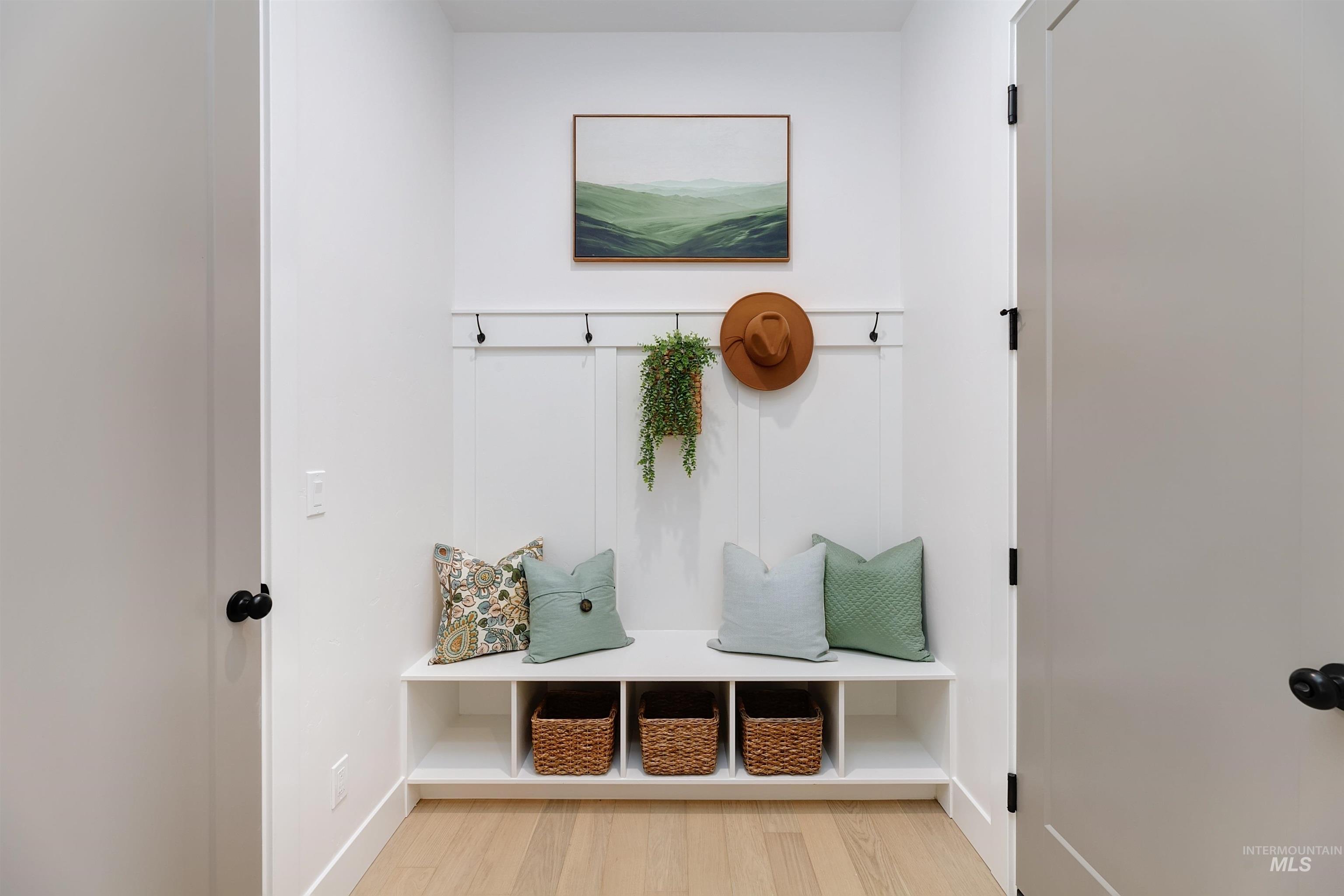 Mudroom with light wood finished floors and baseboards
