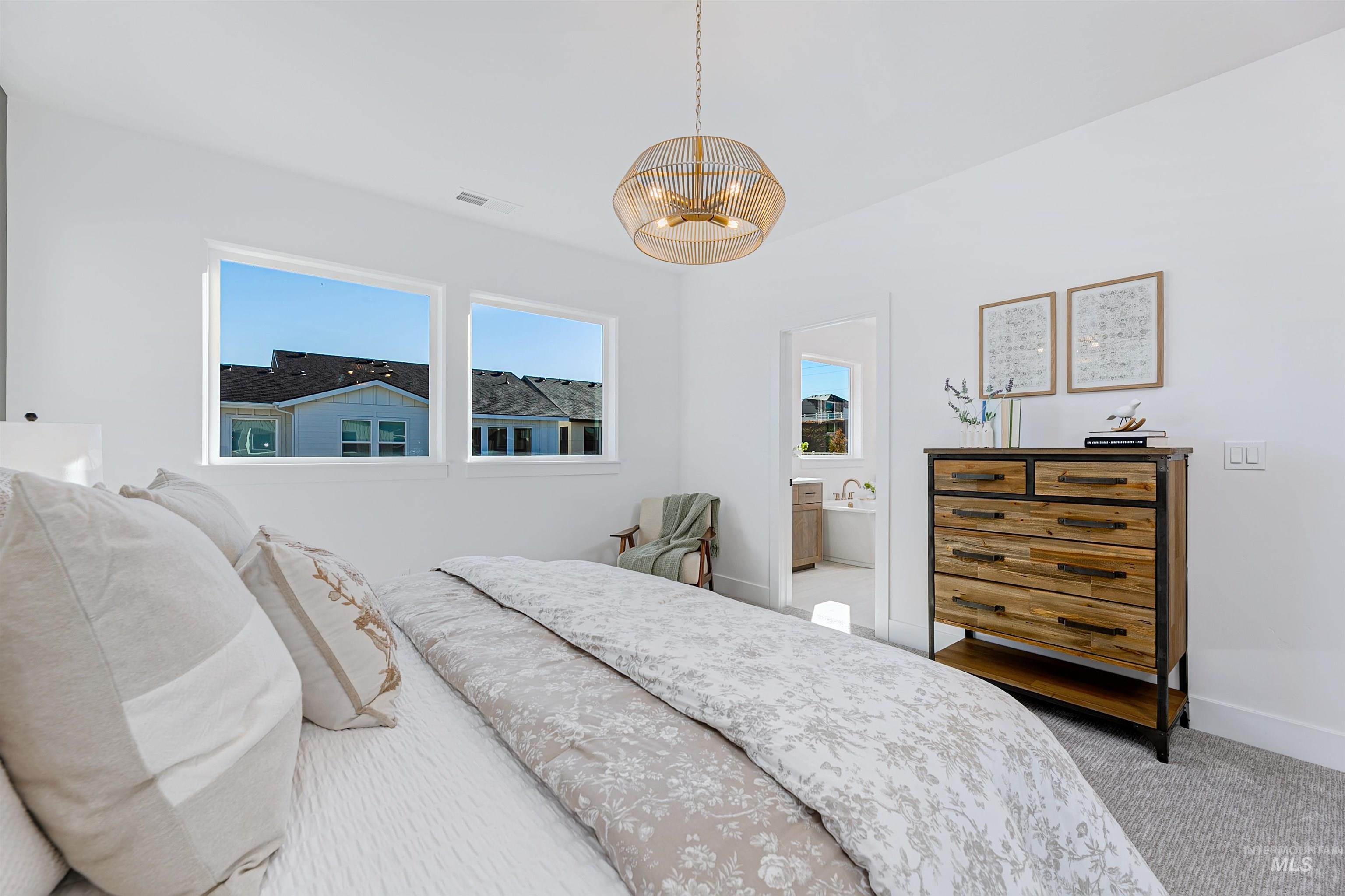 Bedroom with carpet floors, a chandelier, and ensuite bath