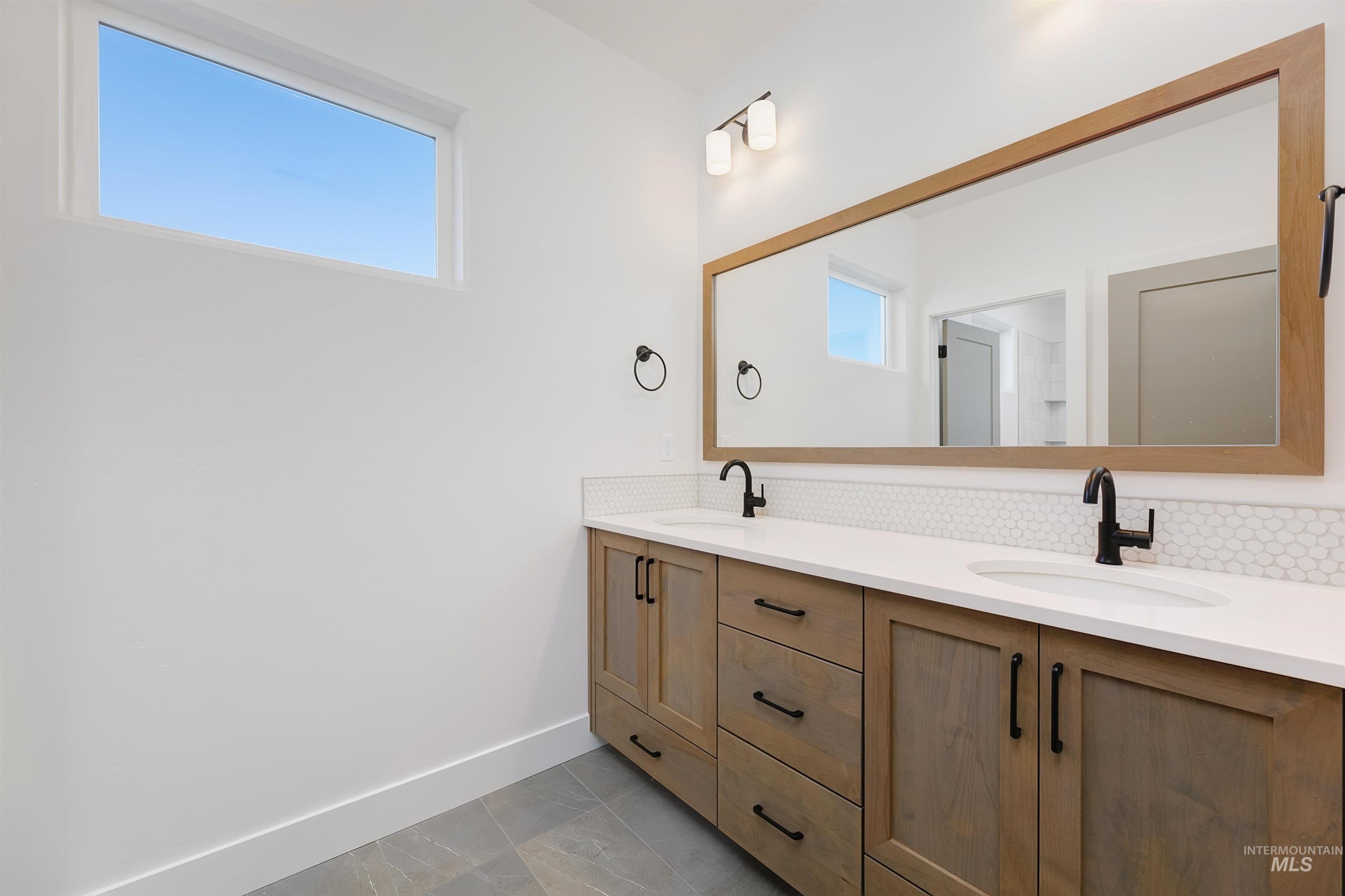 Bathroom with double vanity and tasteful backsplash