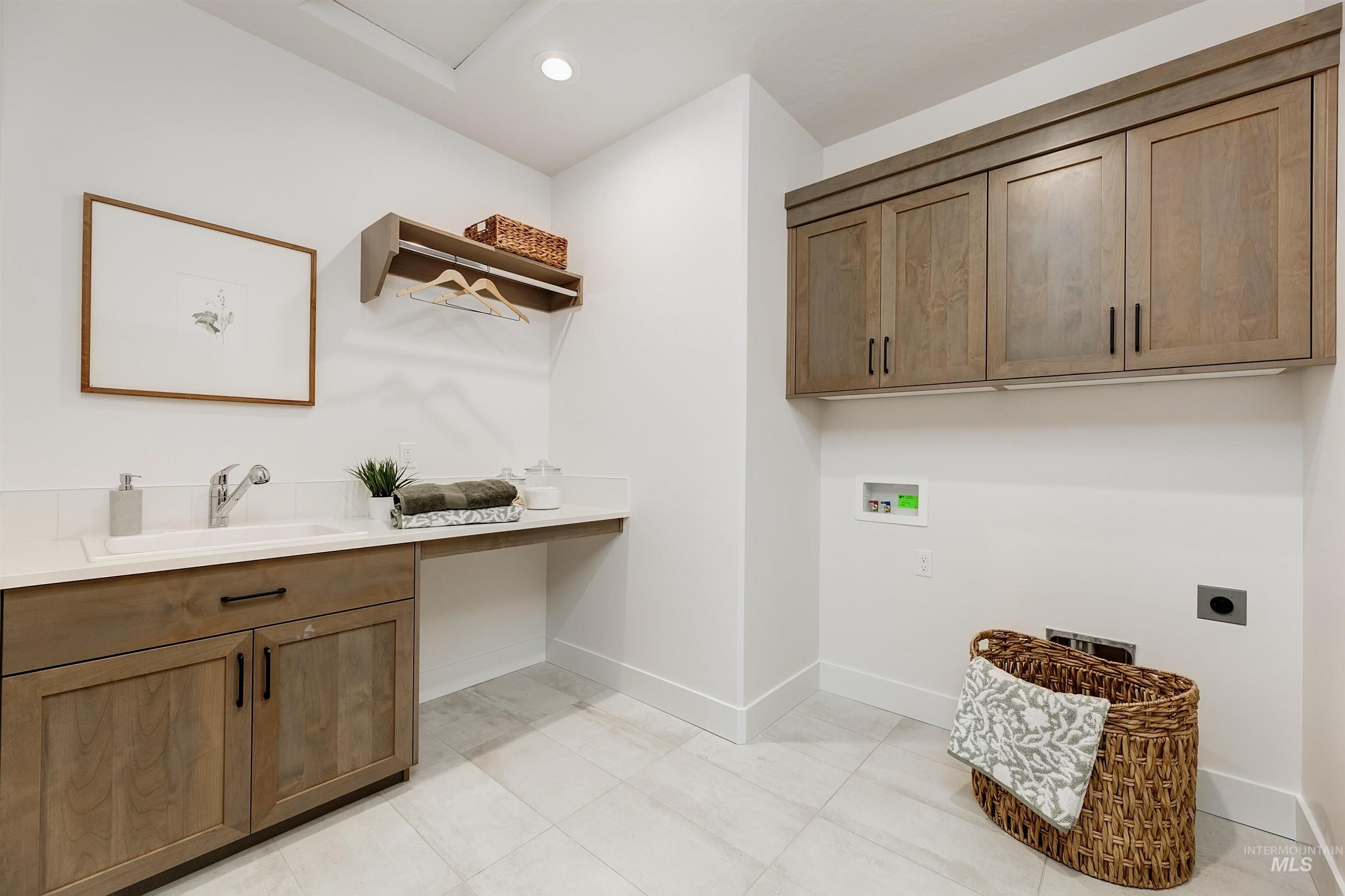 Laundry area featuring cabinet space, hookup for a washing machine, hookup for an electric dryer, recessed lighting, and light tile patterned floors