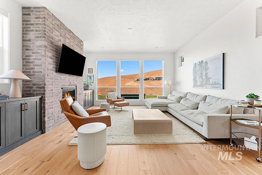 Living room featuring light wood-style floors, a fireplace, and a textured ceiling