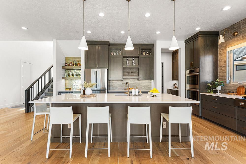 Kitchen featuring appliances with stainless steel finishes, open shelves, dark brown cabinets, recessed lighting, and a textured ceiling