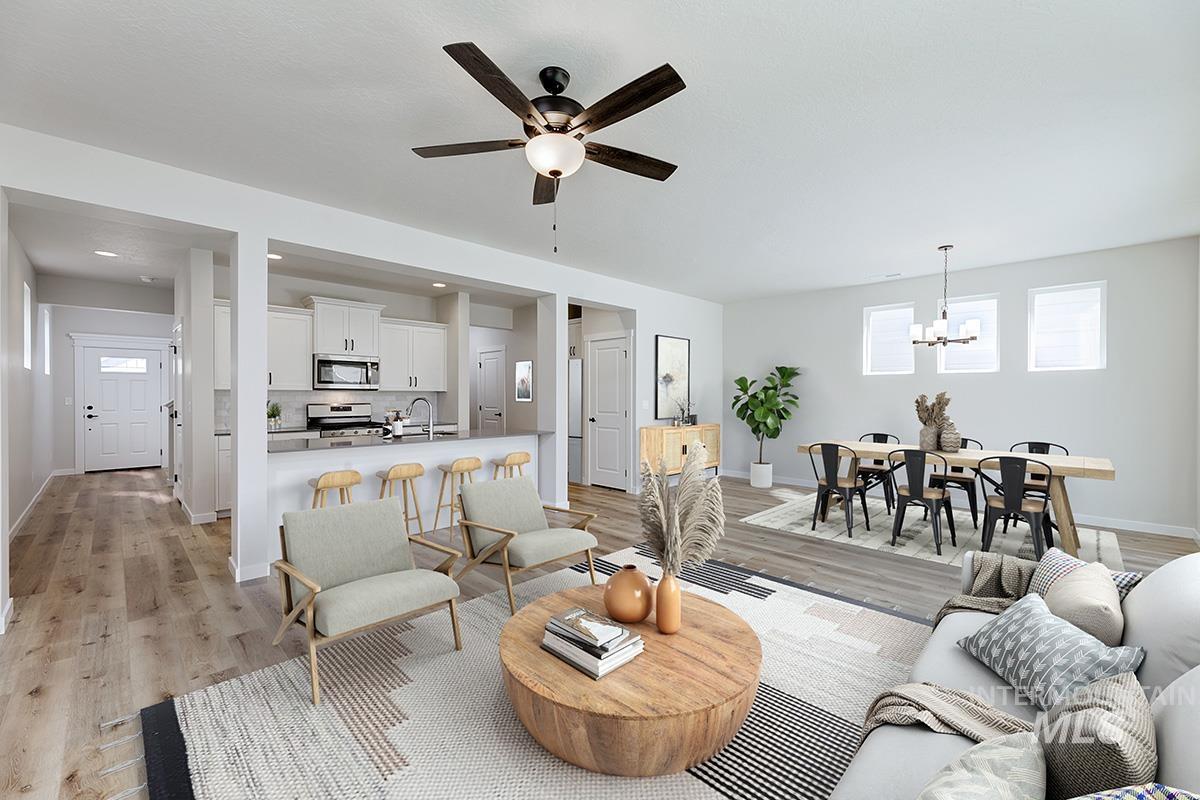 Living area with light wood-style flooring, ceiling fan, and a chandelier