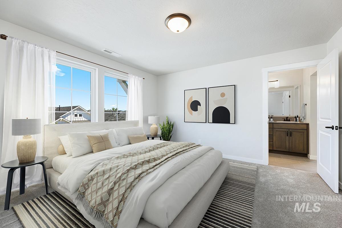 Bedroom with light carpet and connected bathroom