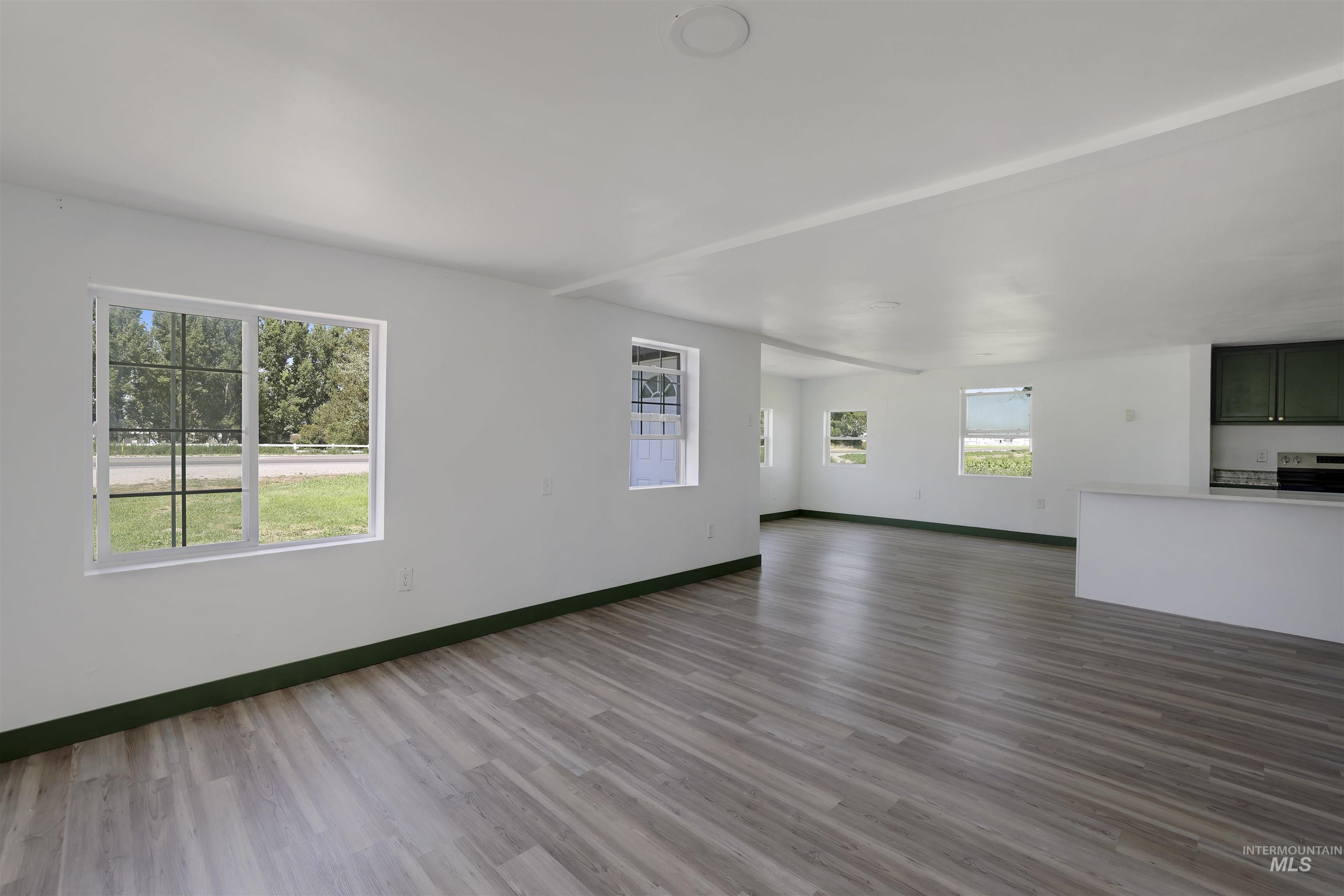 Unfurnished living room with baseboards and dark wood finished floors