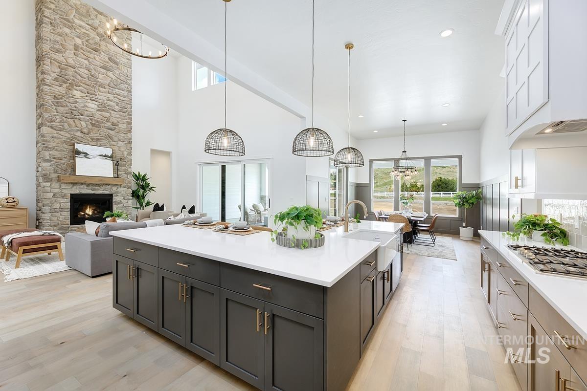 Kitchen with open floor plan, a chandelier, light wood-style floors, a fireplace, and decorative light fixtures