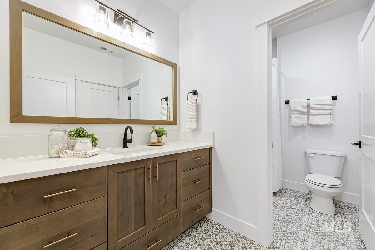 Bathroom featuring vanity, light tile patterned flooring, and a shower with shower curtain