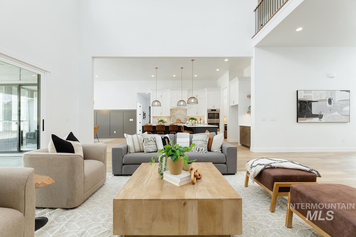 Living room featuring a high ceiling, light wood-type flooring, and recessed lighting