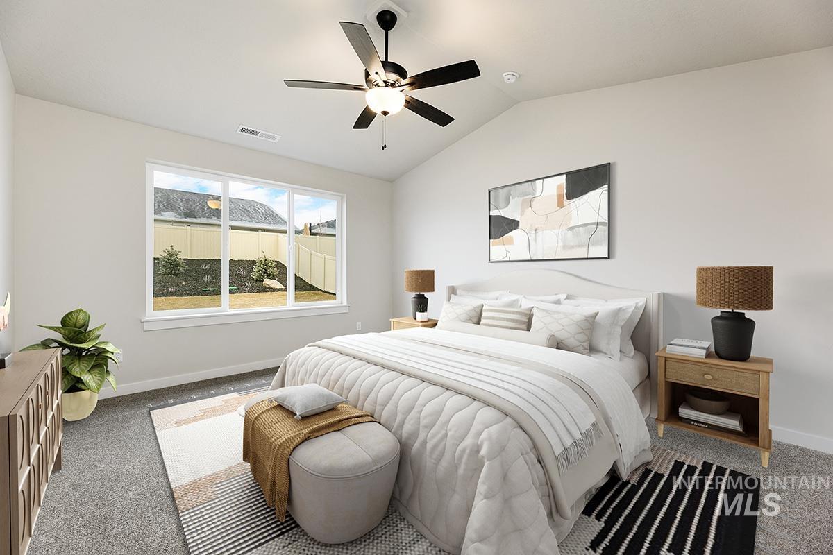 Carpeted bedroom with lofted ceiling and ceiling fan