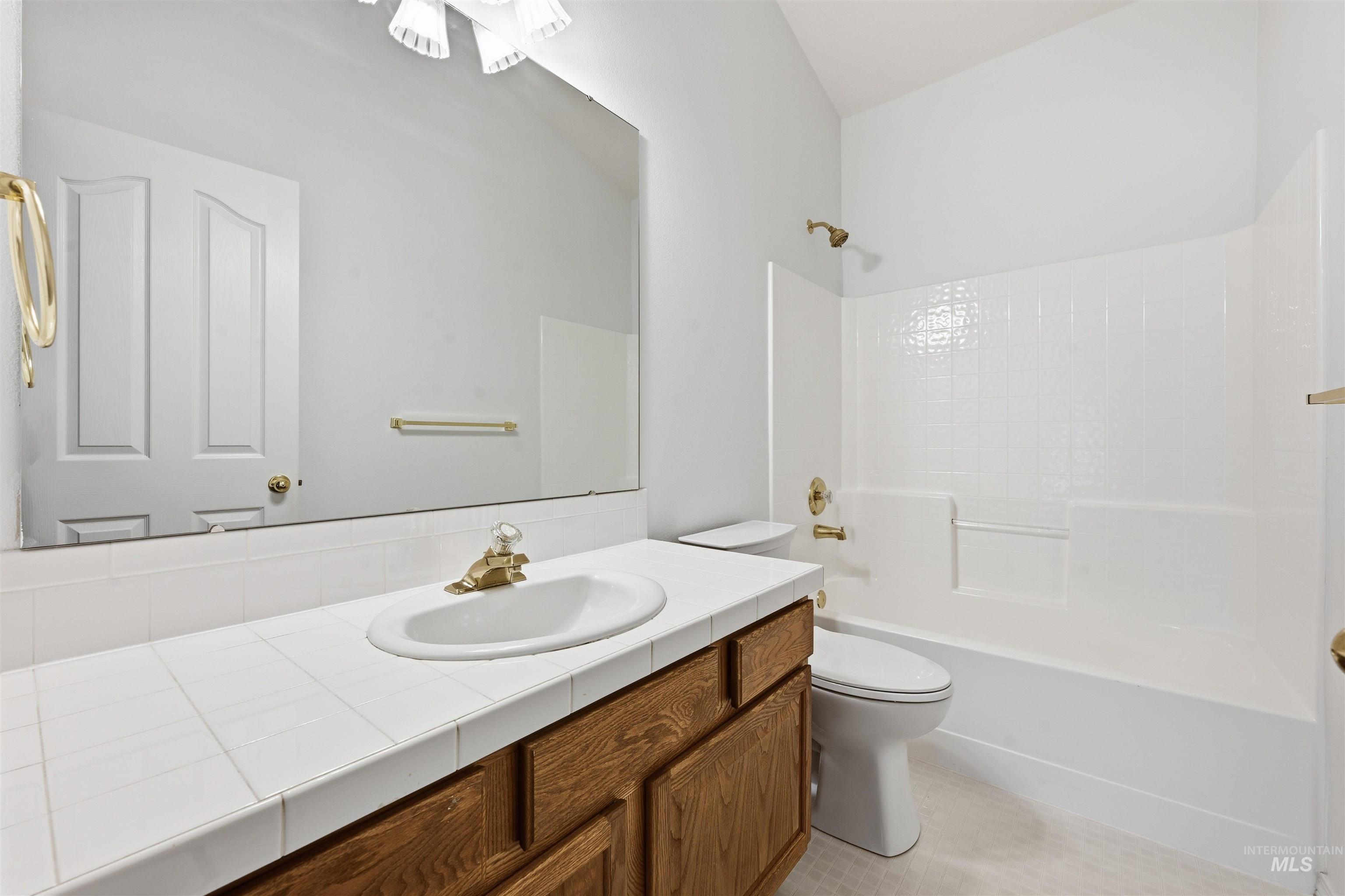 Bathroom featuring vanity, shower / bathtub combination, and light tile patterned floors