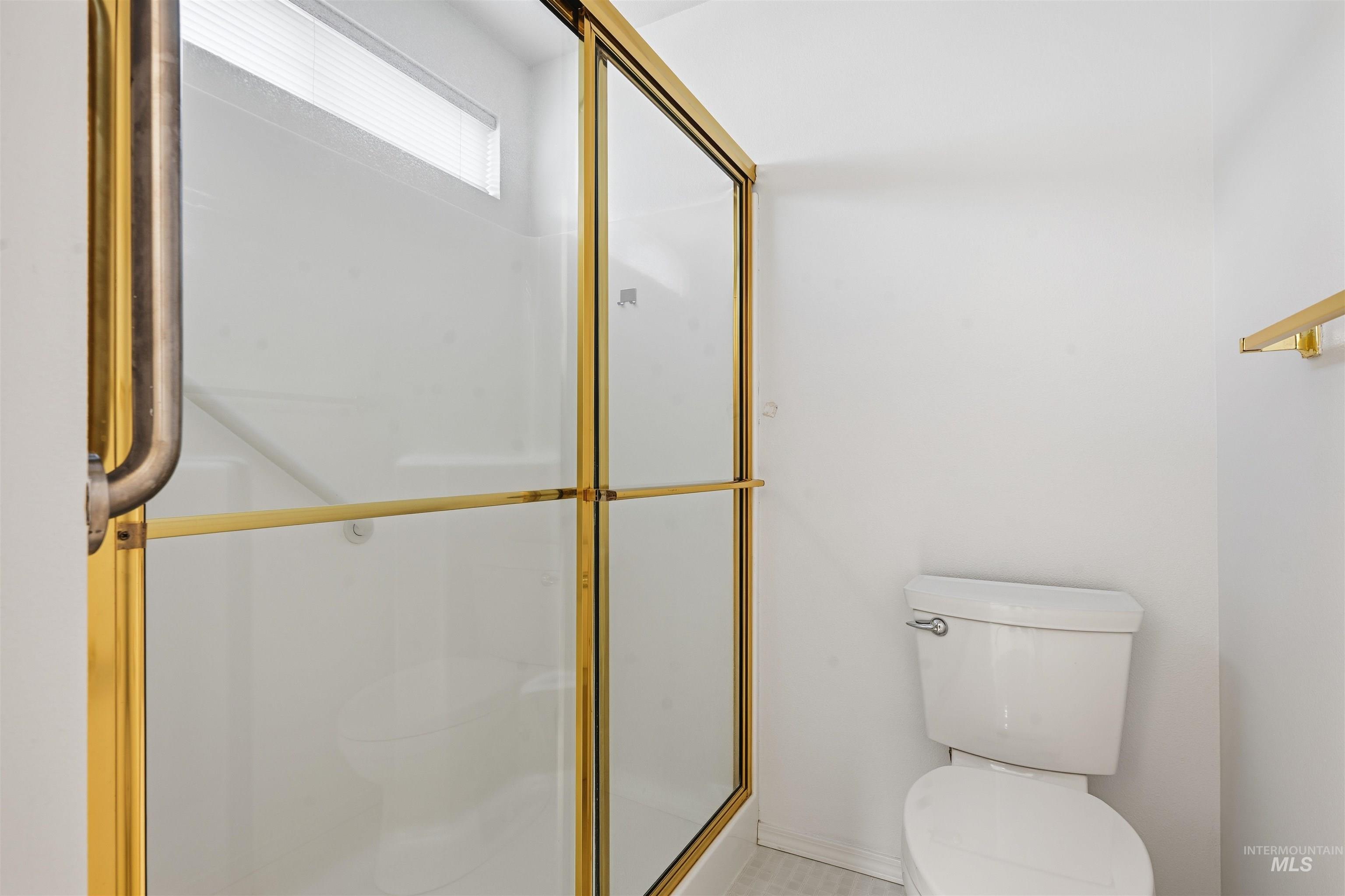 Bathroom featuring toilet and a stall shower