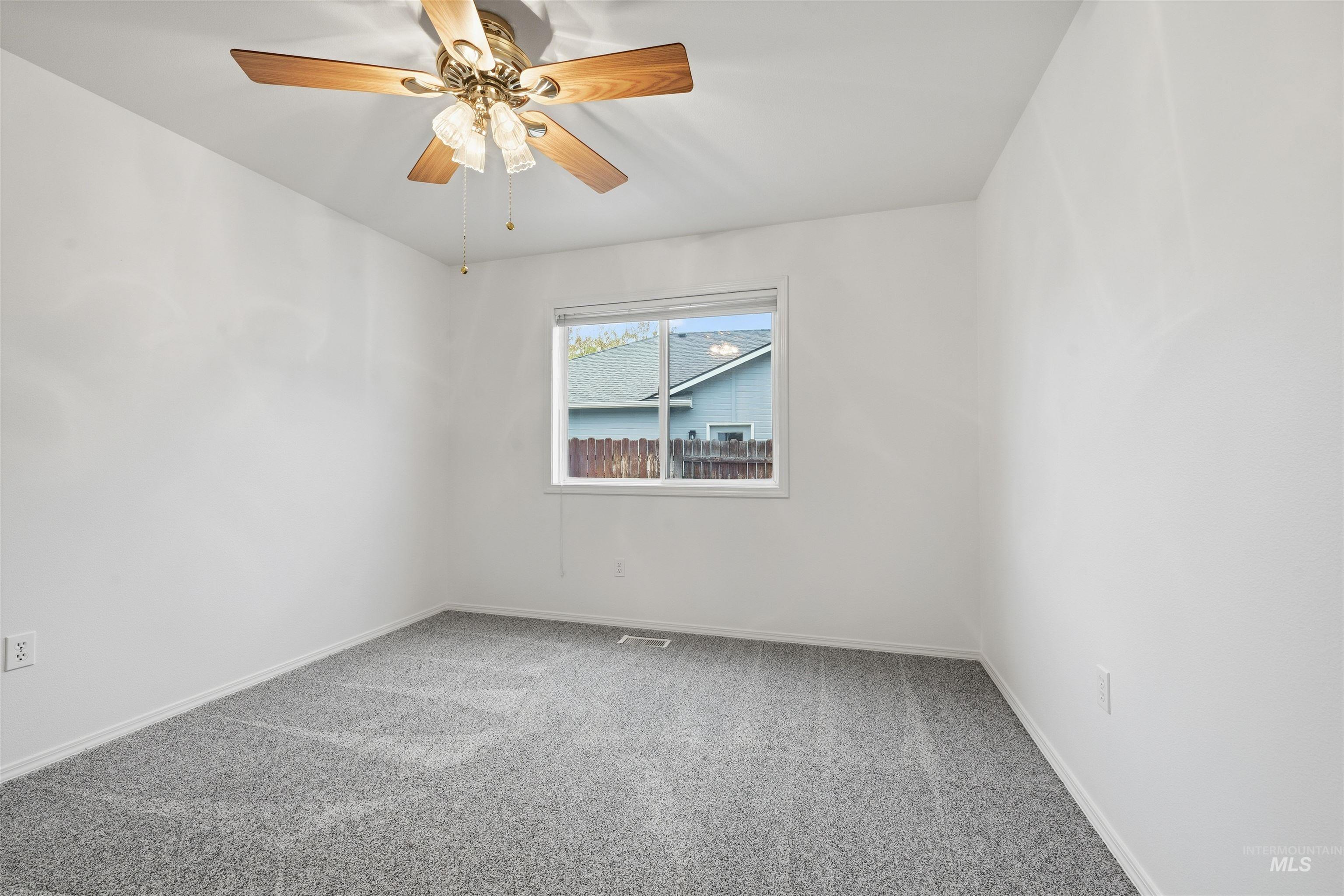Empty room with light carpet and ceiling fan