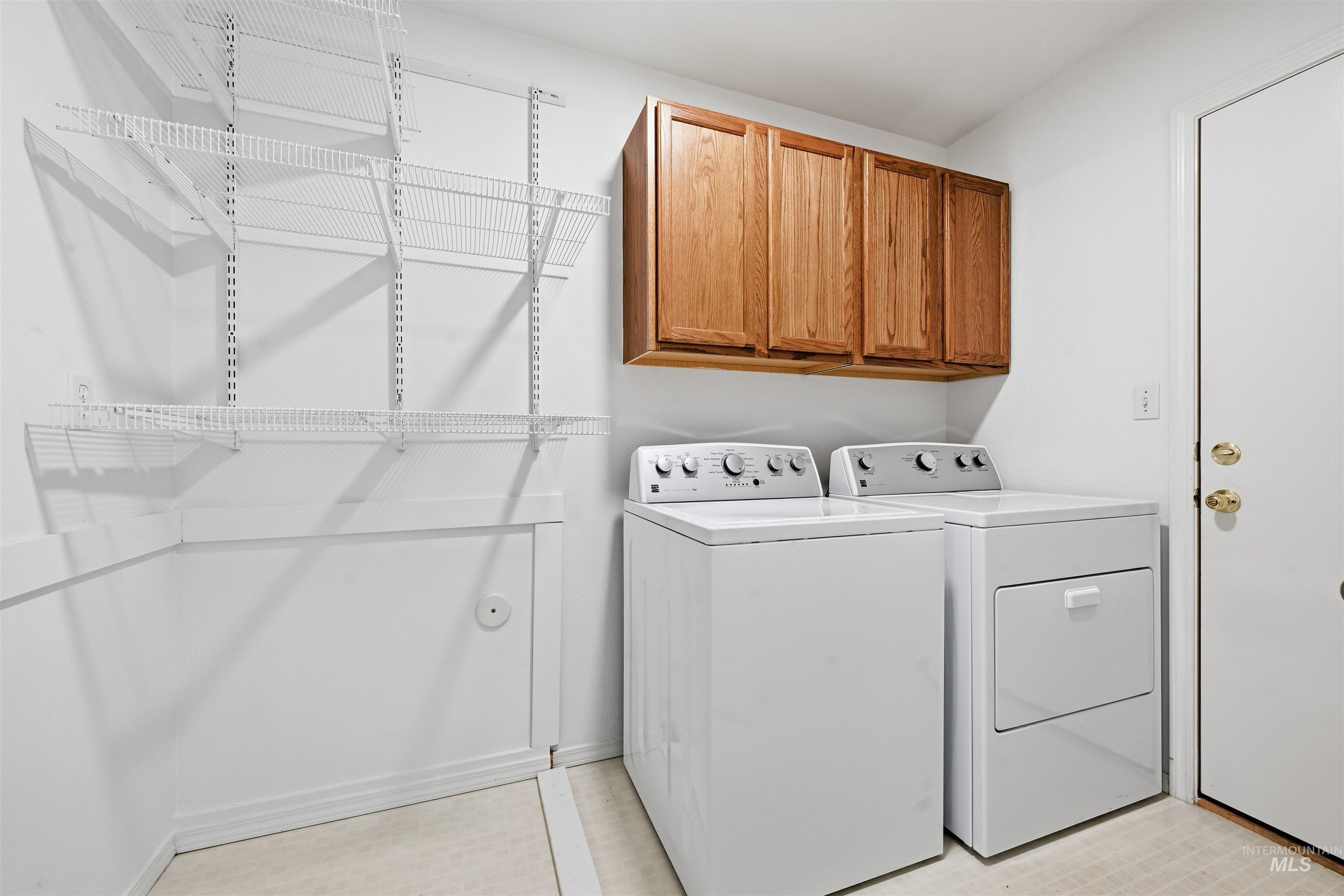 Washroom featuring cabinet space and washer and dryer