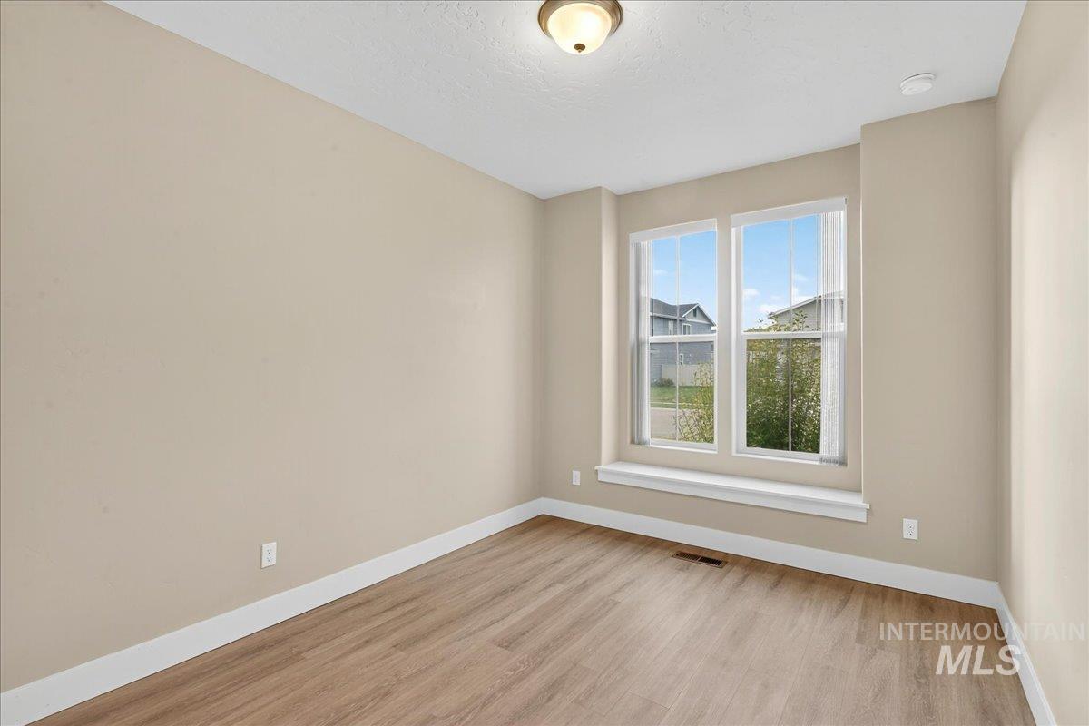 Empty room featuring light wood-style flooring and a textured ceiling