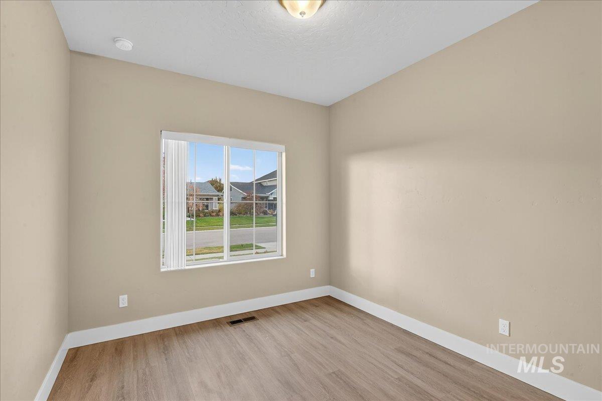 Empty room featuring light wood-style floors and a textured ceiling