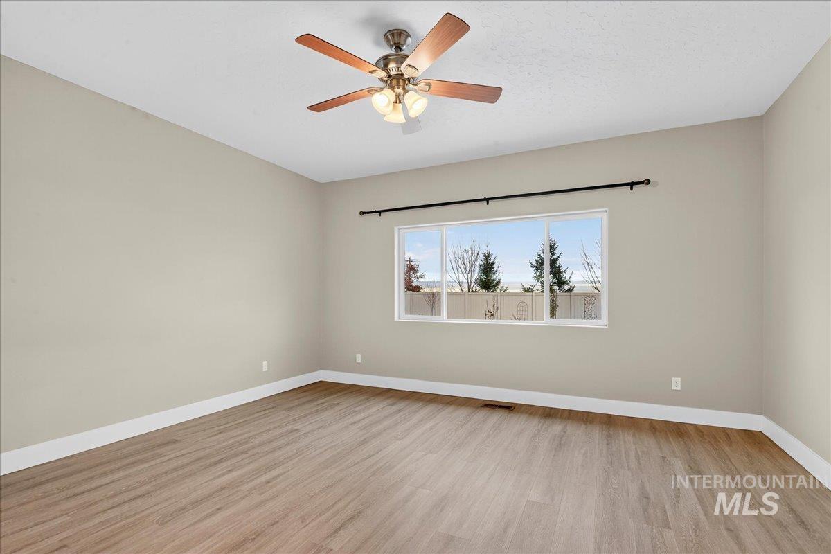 Unfurnished room featuring light wood-style floors and ceiling fan