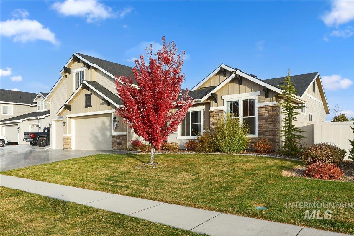 Craftsman house featuring board and batten siding, stone siding, a garage, concrete driveway, and a shingled roof