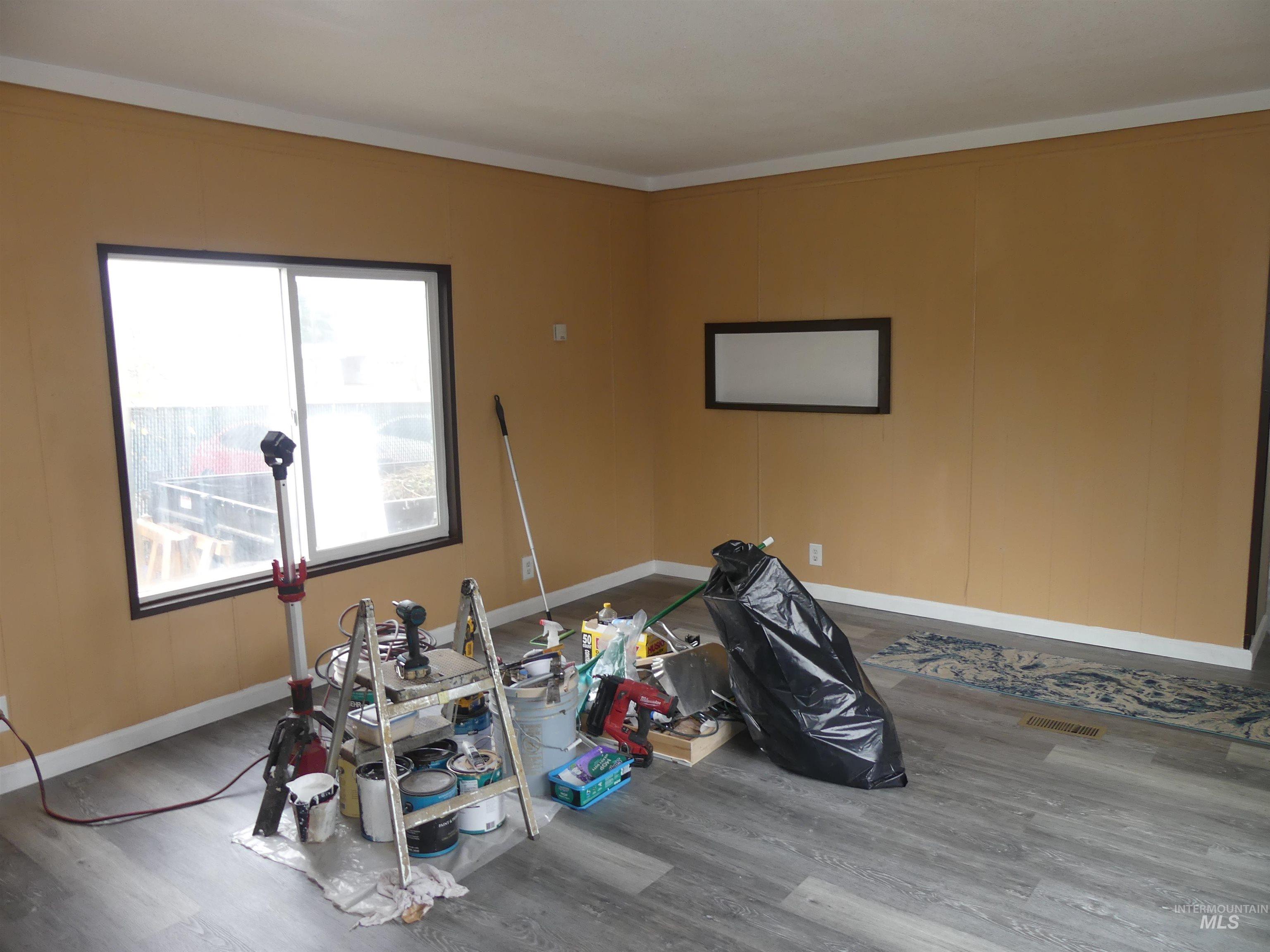 Game room with wood finished floors and ornamental molding