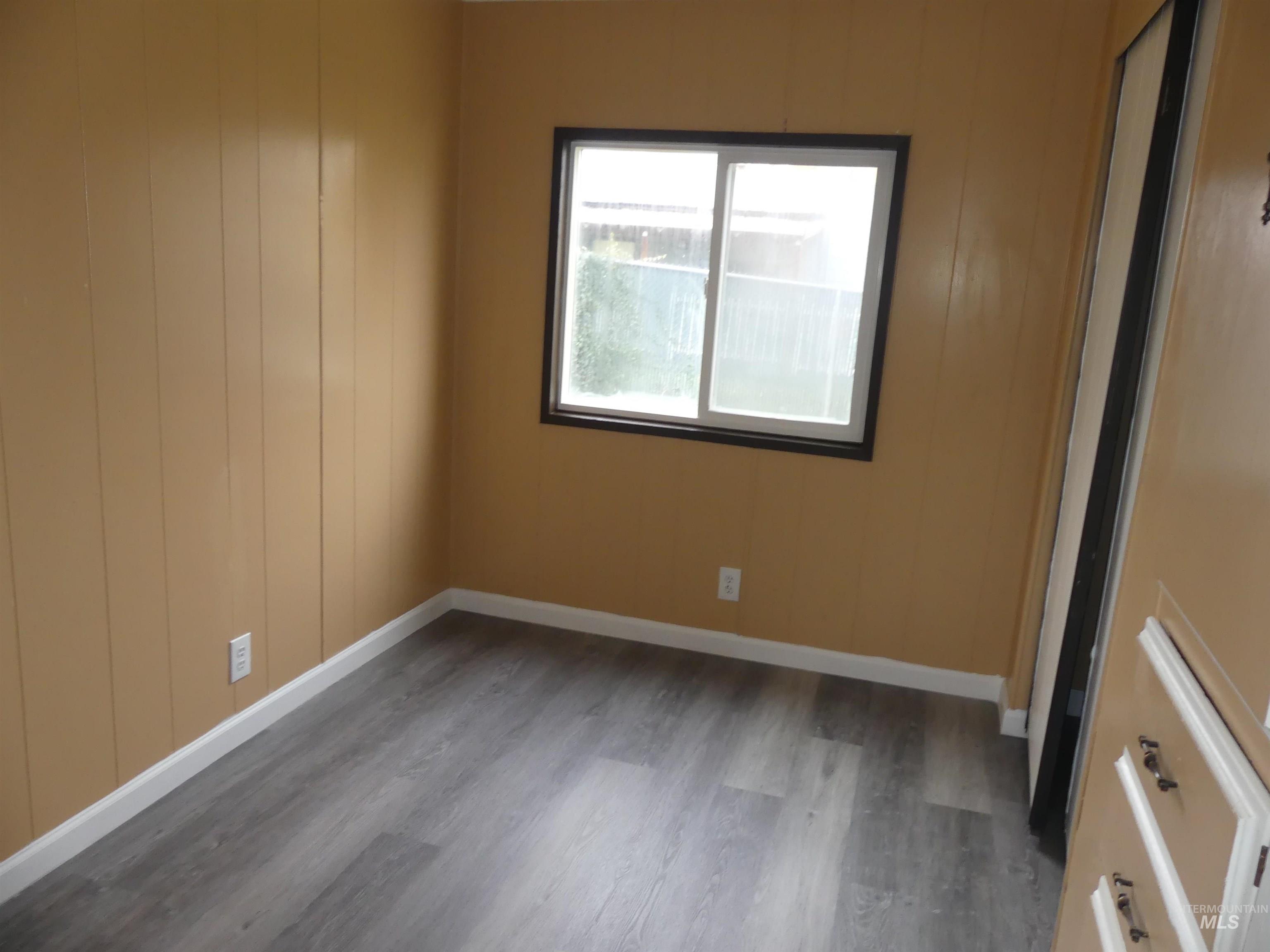 Spare room with wood finished floors and wooden walls