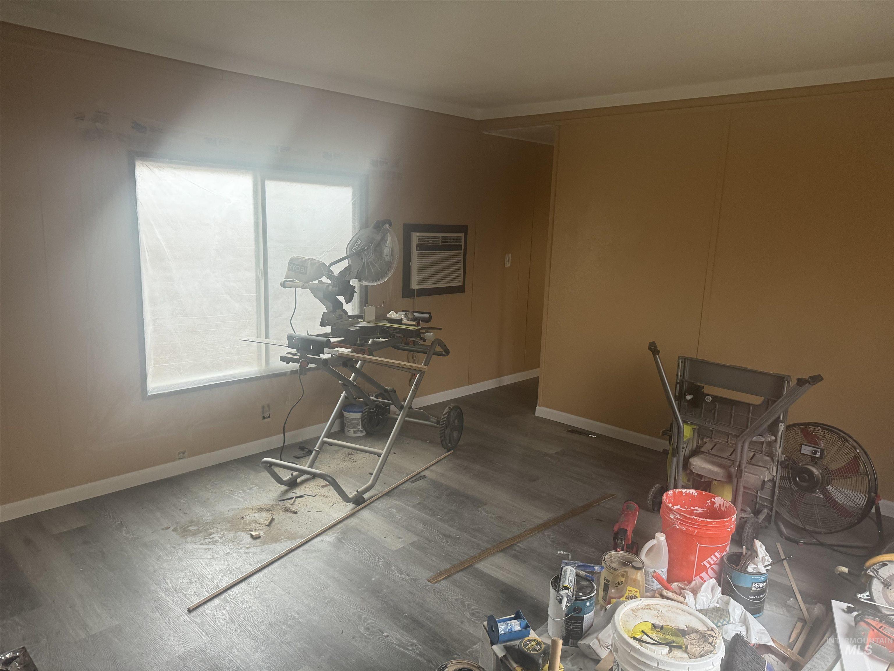 Misc room with wood finished floors and a wall unit AC