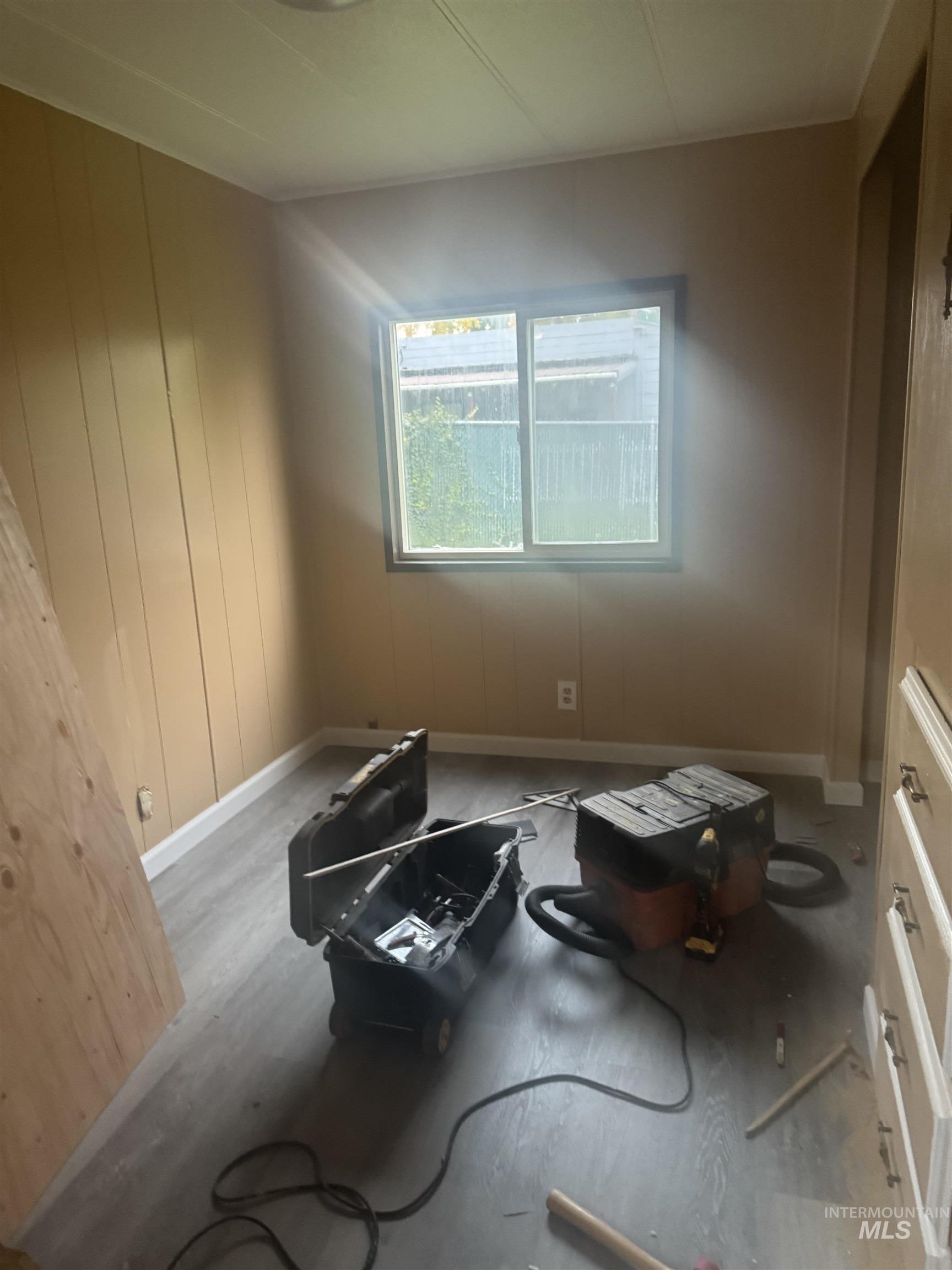 Spare room featuring wood finished floors and wooden walls