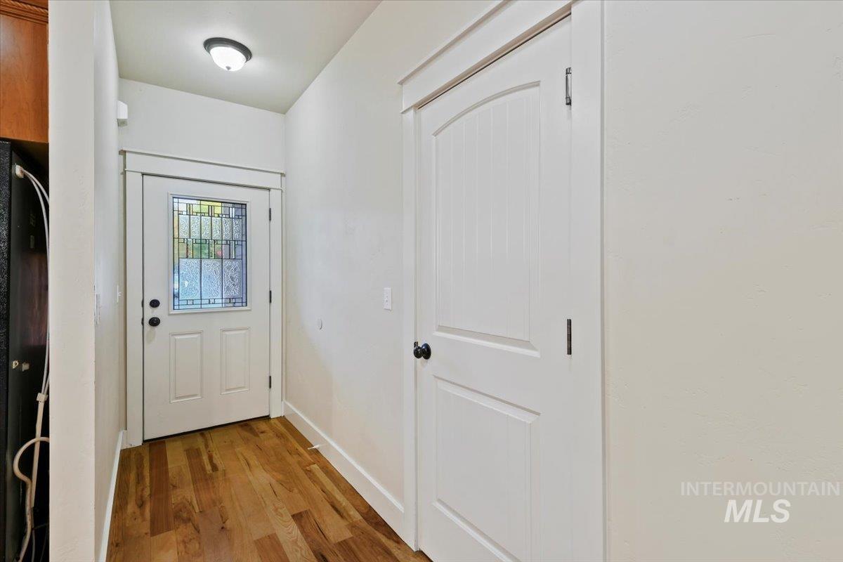 Doorway to outside featuring wood finished floors and baseboards