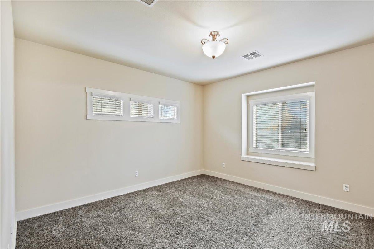 Carpeted spare room with baseboards