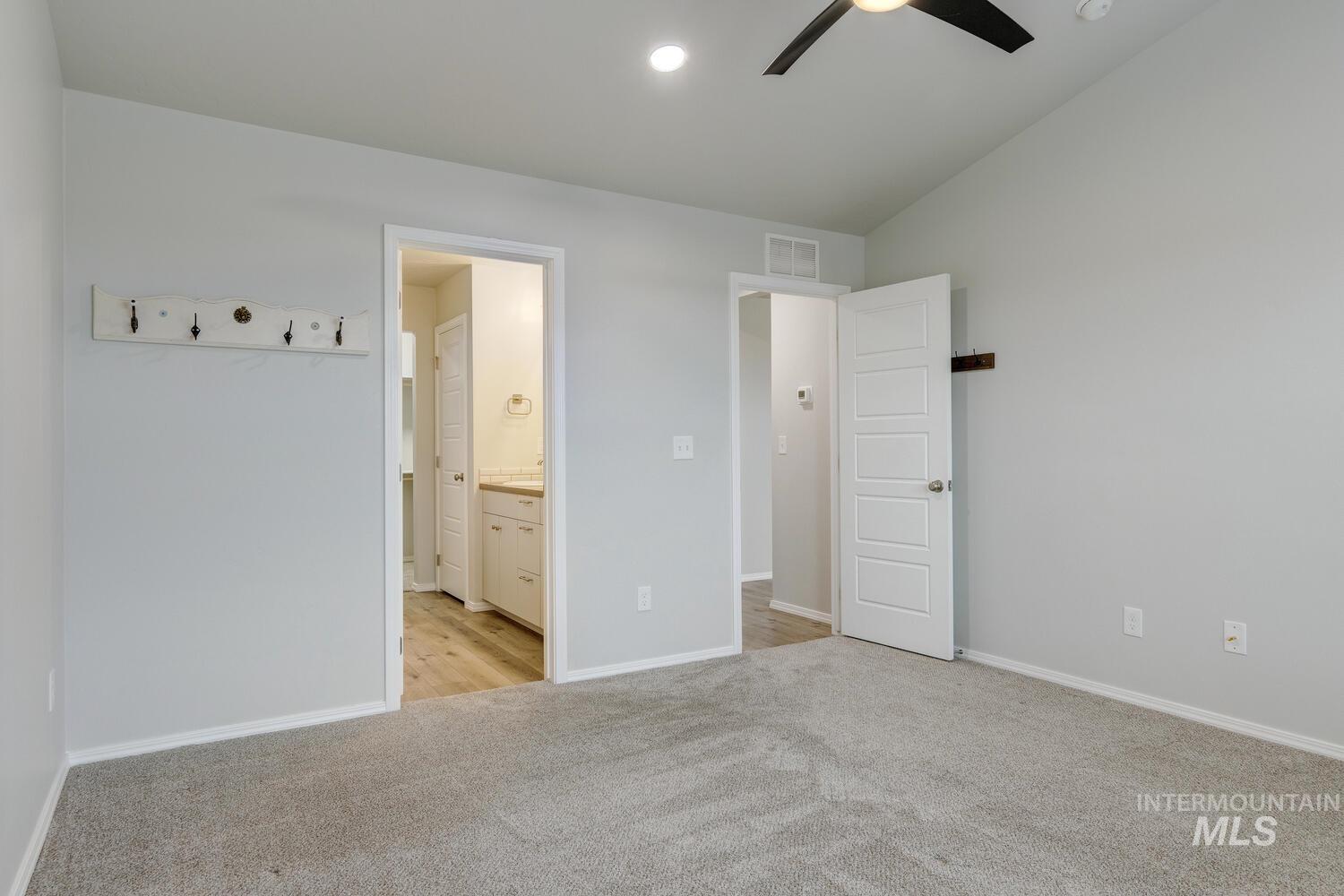 Unfurnished bedroom with light colored carpet, ceiling fan, connected bathroom, and recessed lighting