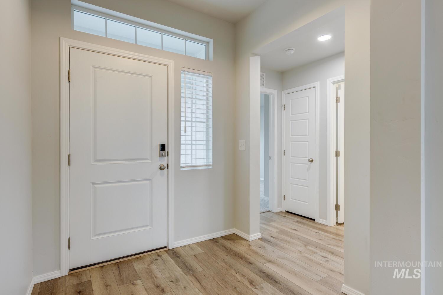 Entryway with light wood-style floors and baseboards