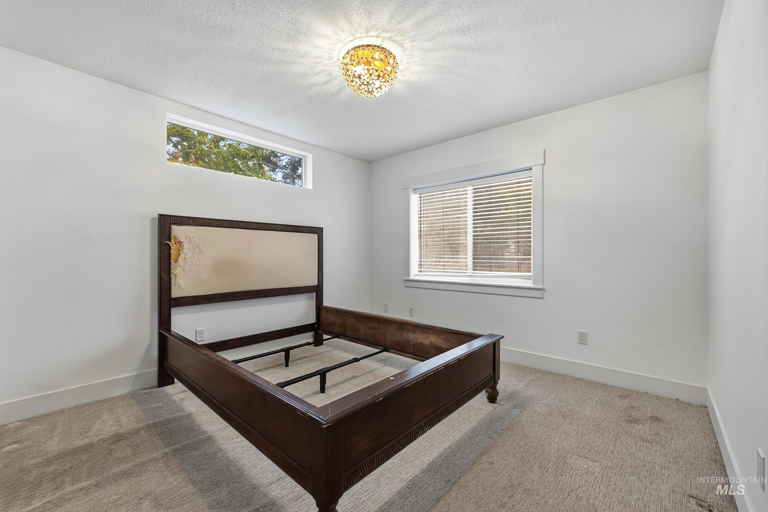 Bedroom with light carpet and a textured ceiling