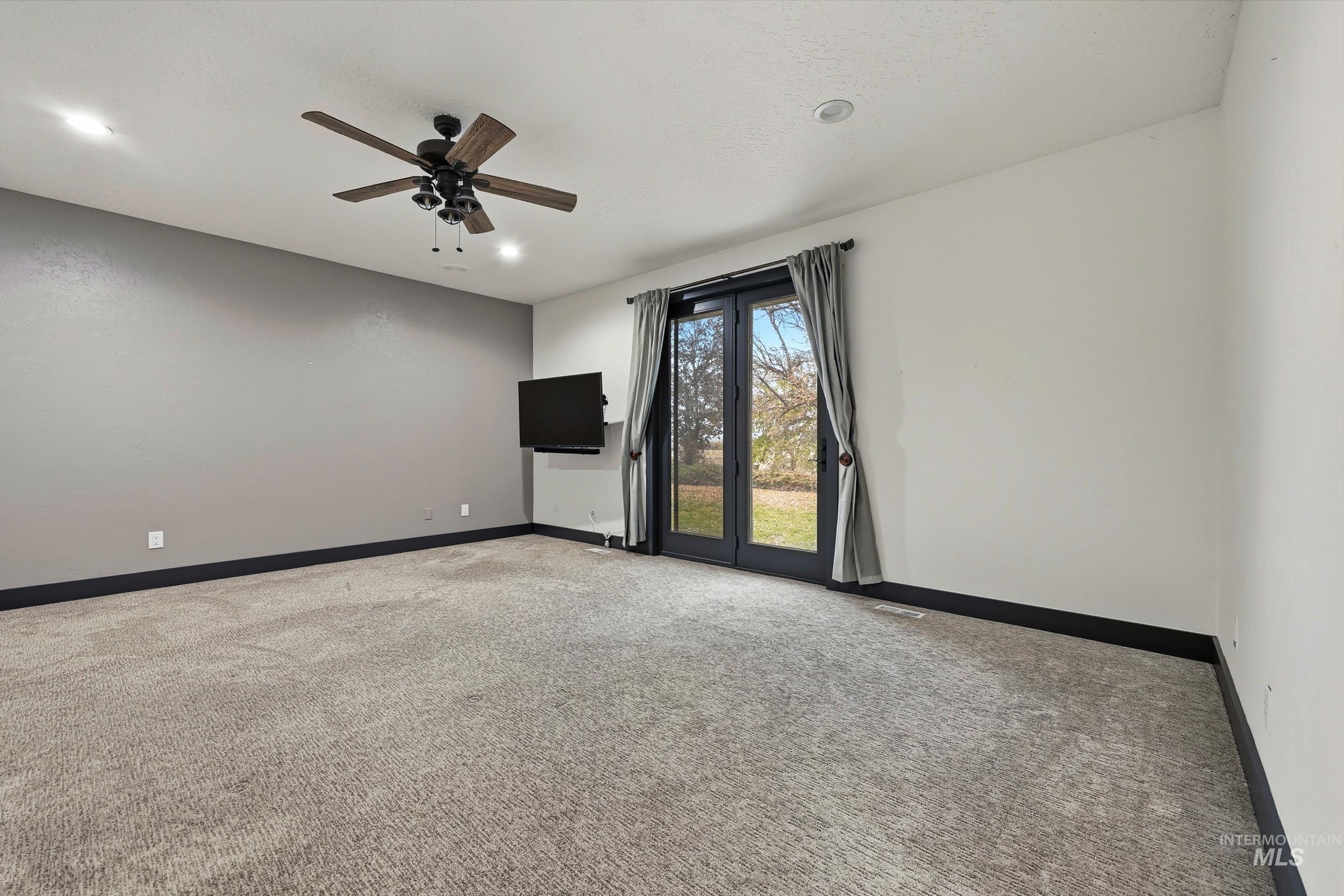 Unfurnished room featuring light colored carpet and ceiling fan